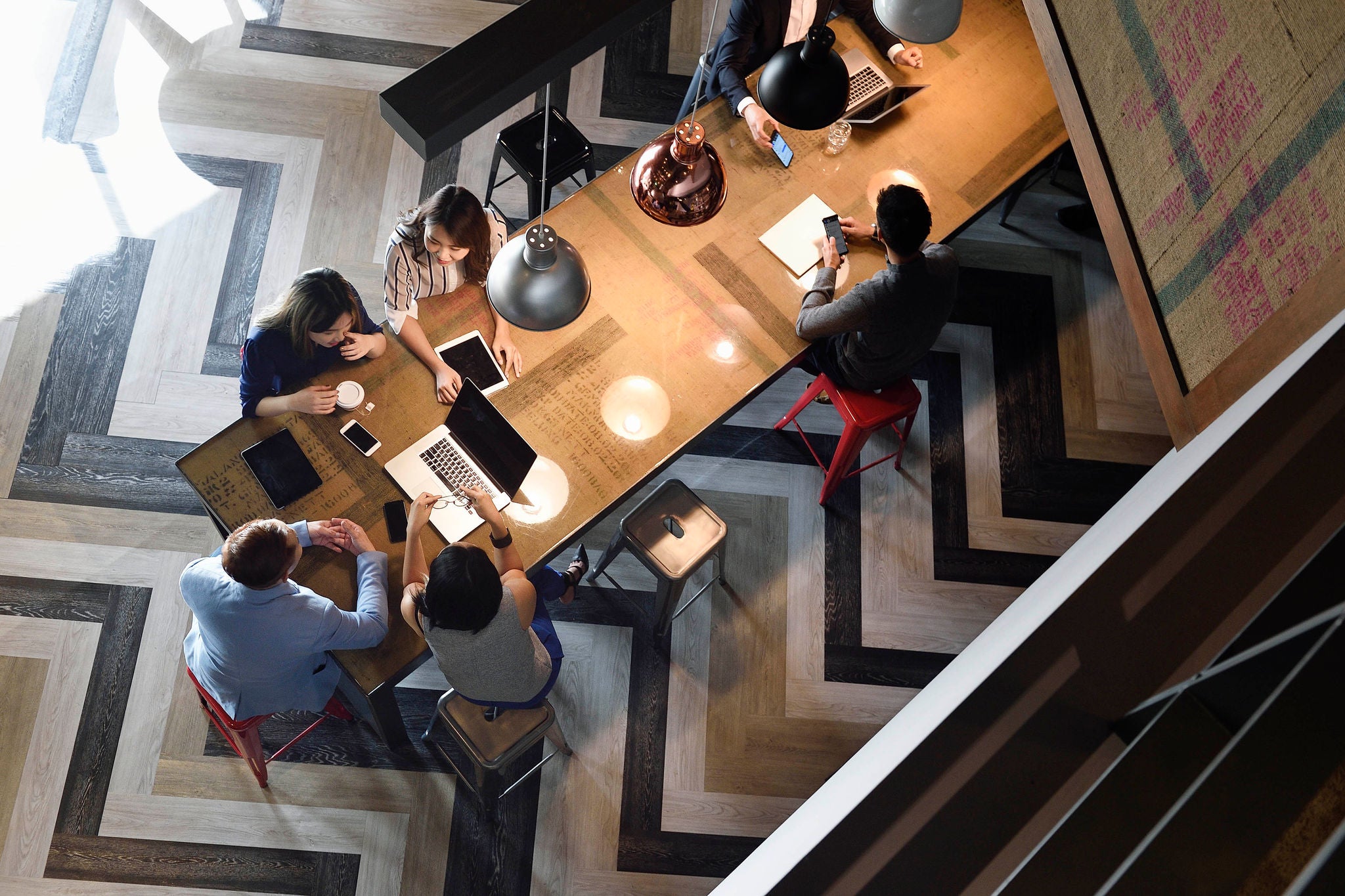 Young Chinese colleagues working together in a busy co-working space from above