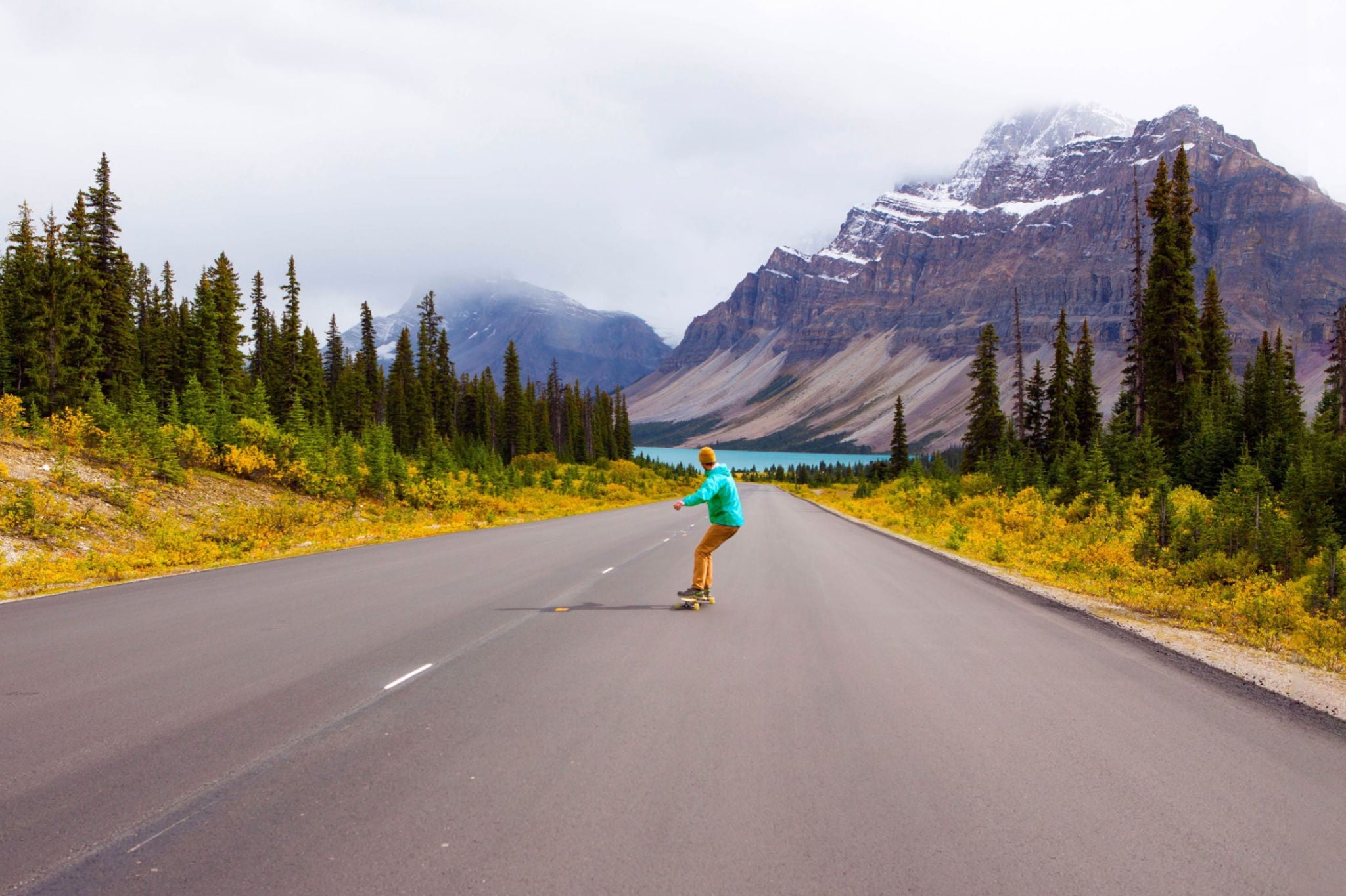 A man longboarding down a scenic road