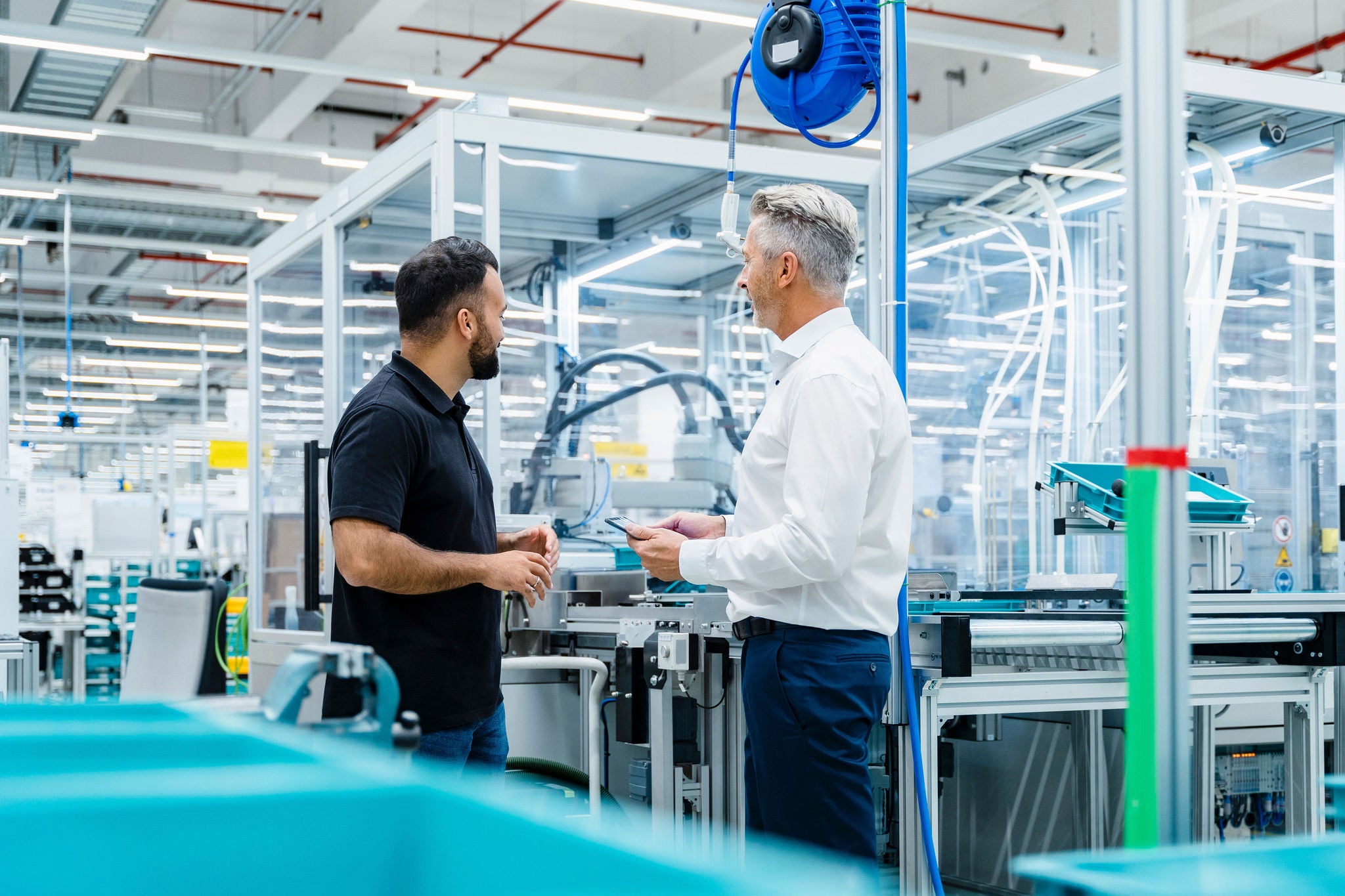 Businessman having discussion with engineer at factory production line