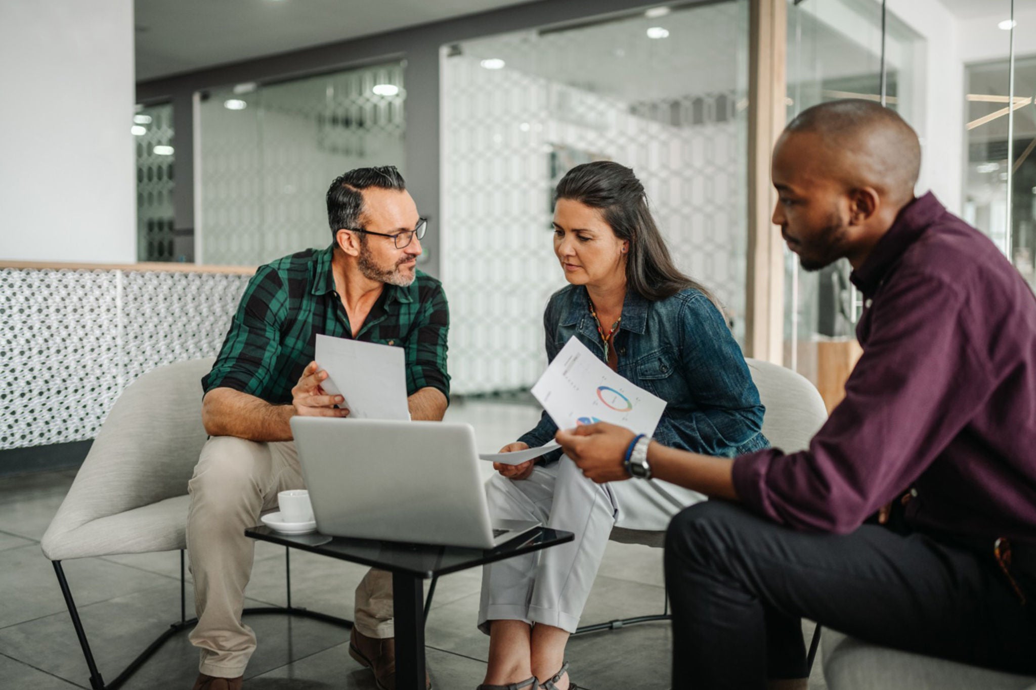 Casual meeting of diverse business team analyzing financial data