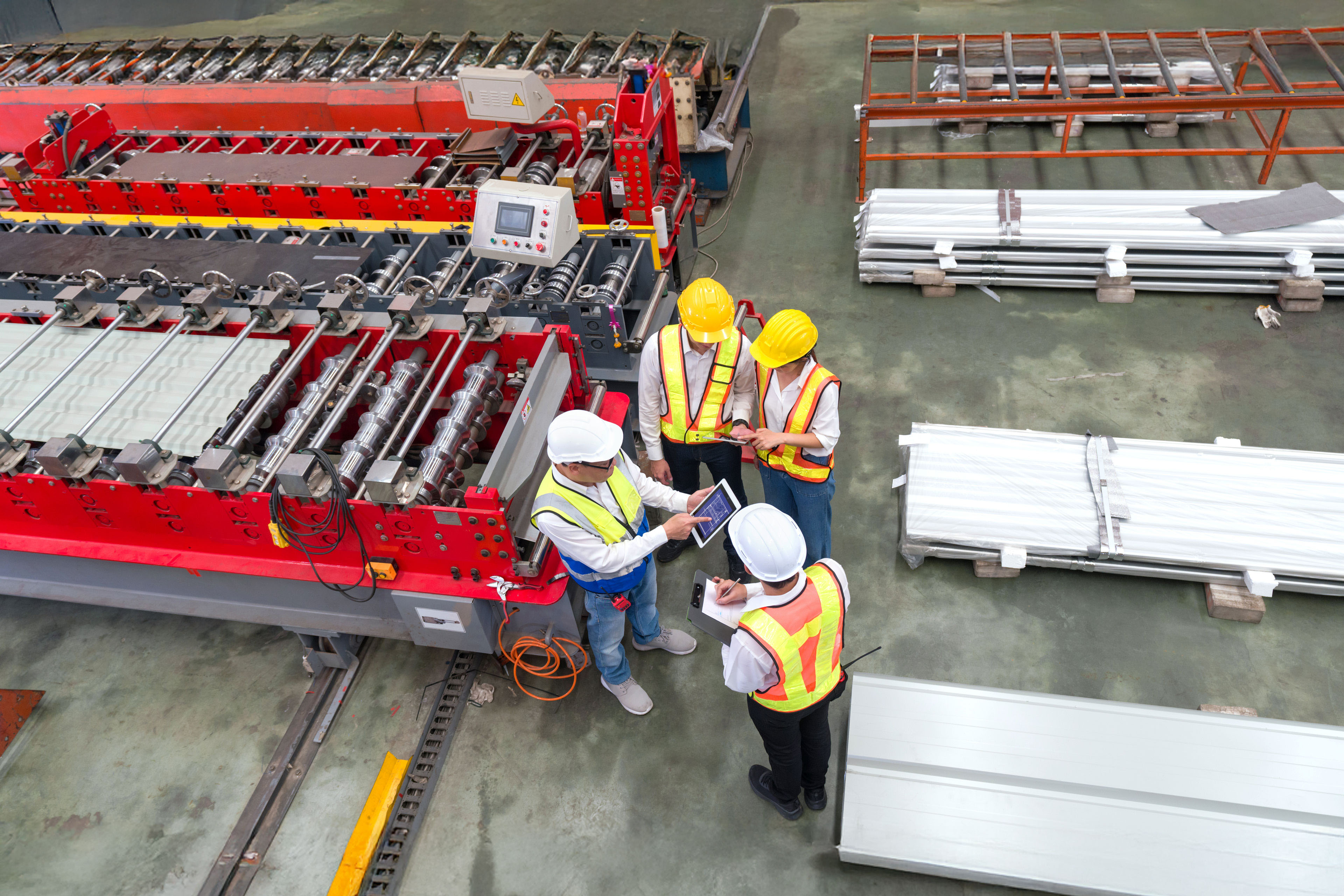 Senior engineer manager trains new employees within the metal sheet factory